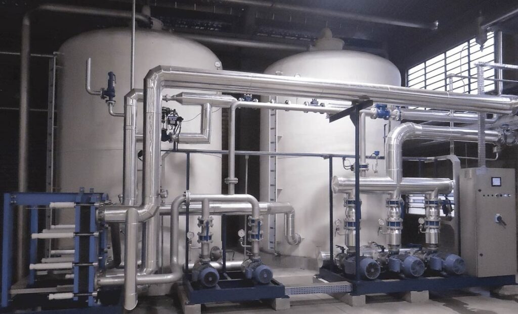 Equipamento industrial com tanques e tubulações metálicas demonstrando o funcionamento de sistemas térmicos baseados em os processos de troca de calor.